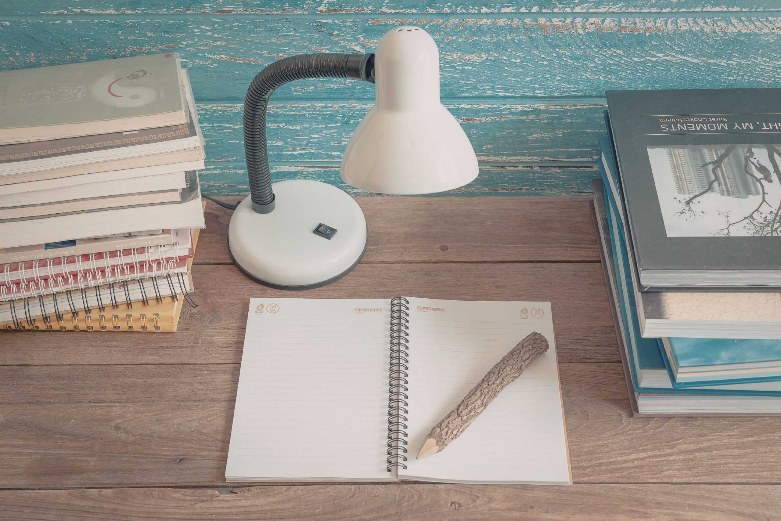 Stack of personal finance and financial independence books on a wooden table with a notebook and symbolizing intentional money learning